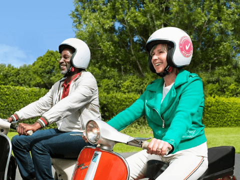 two over 50 adults with helmets on riding mopeds