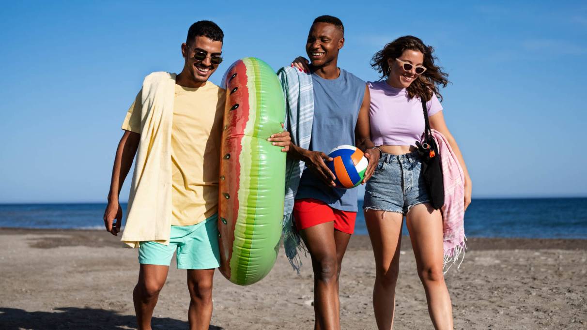 group of friends walking on the beach smiling and being happy