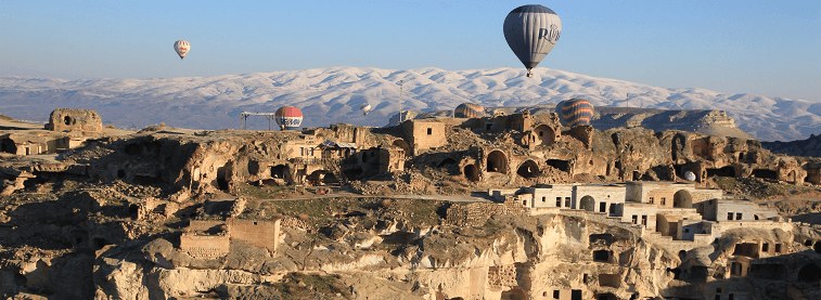 Cappadocia with hot air balloons flying around the sky