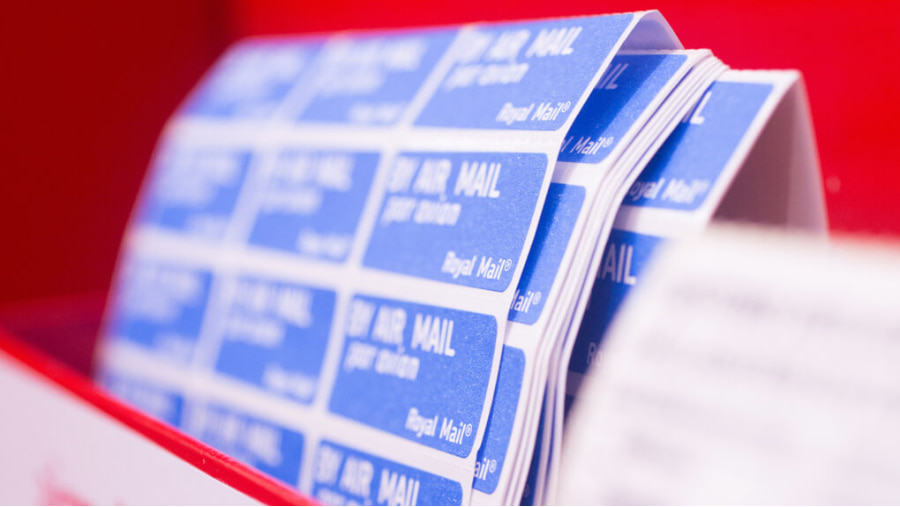 Post Office display shelf with a stack of By Air Mail stickers sat inside