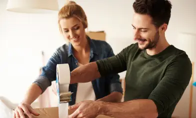 man and lady taping up a box together