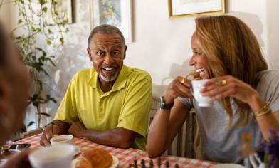 a group of over 60s smiling and drinking a hot beverage