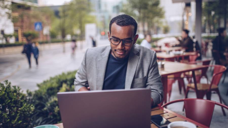 a person working on a laptop at an outdoor cafe