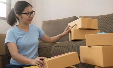 A person packing parcels in cardboard boxes