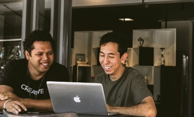 Two individuals engaged in a collaborative work session at a table.