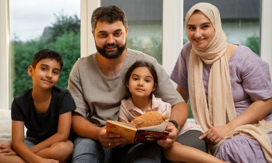 a happy family of four enjoying a children's book