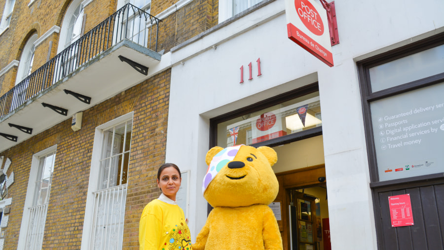 a person standing next to a teddy bear