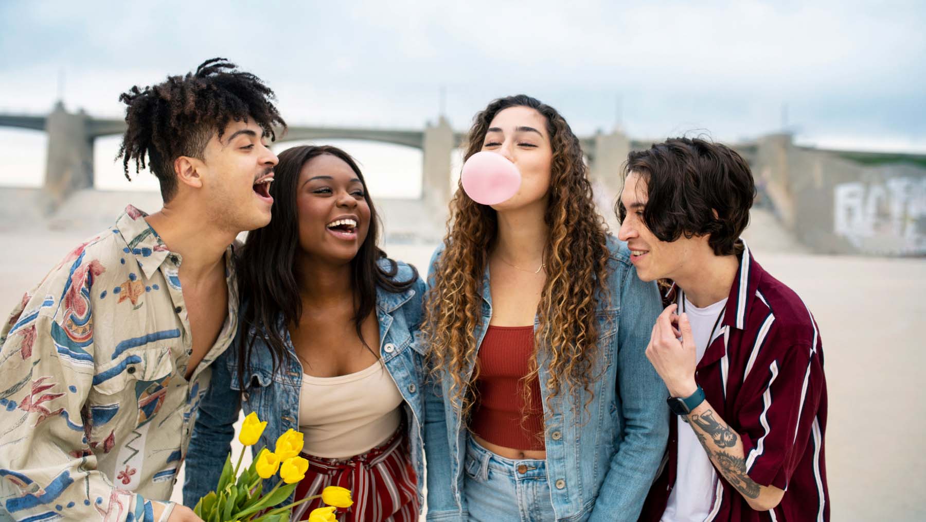 group of friends laughing as one of the girls is blowing a bubble