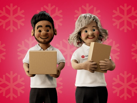 two Post Office Christmas helpers holding parcels