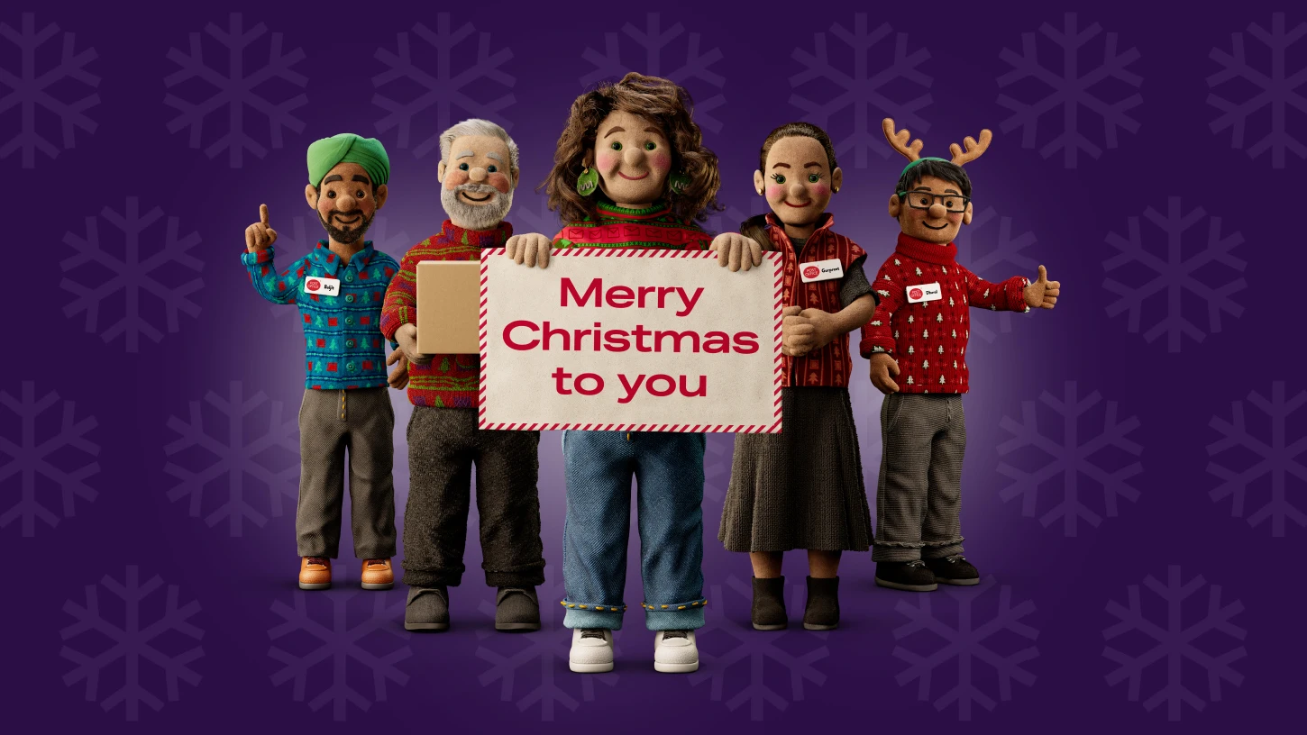 a group of Post Office Christmas helpers holding up a sign that says Merry Christmas to you