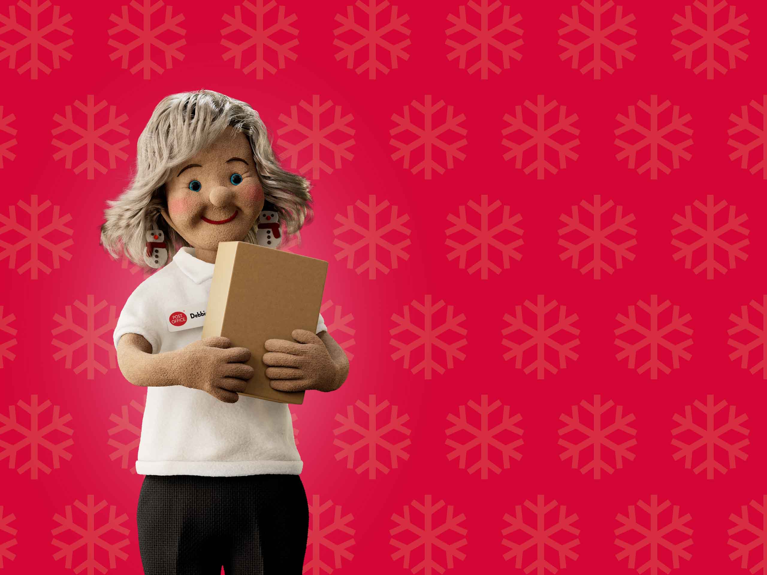 a Post Office Christmas helper holding up a parcel