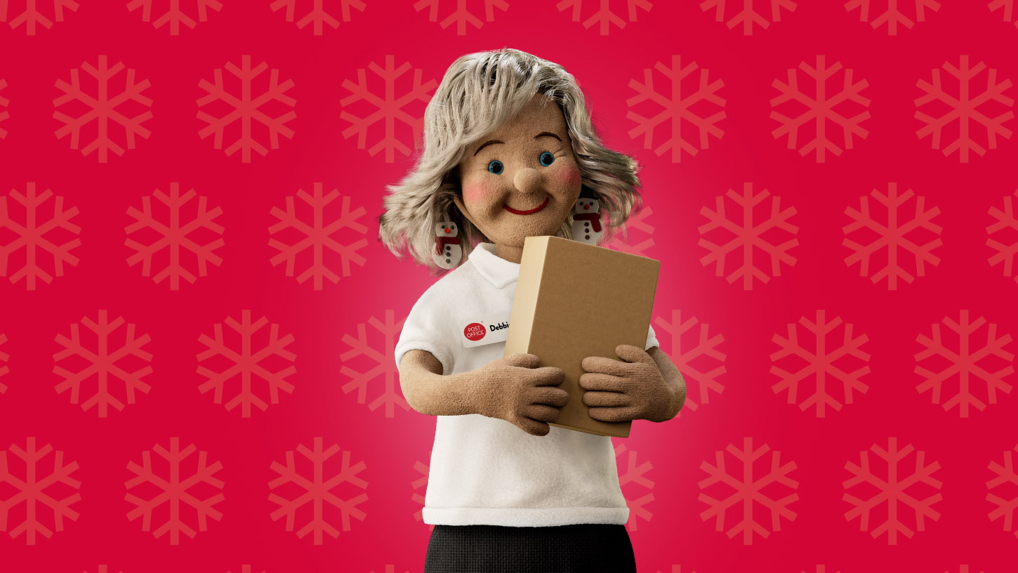 a Post Office Christmas helper holding up a parcel