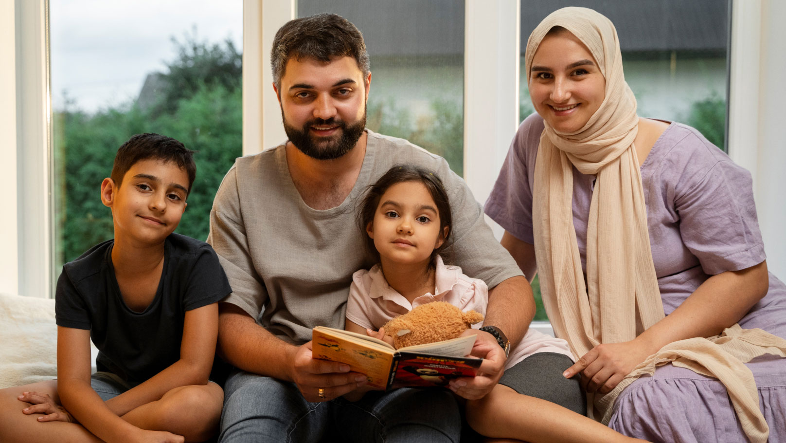 a happy family of four enjoying a children's book