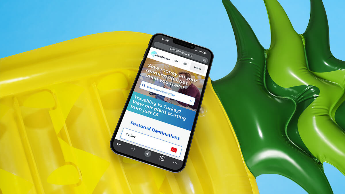 a mobile phone resting on a large pineapple shaped pool float