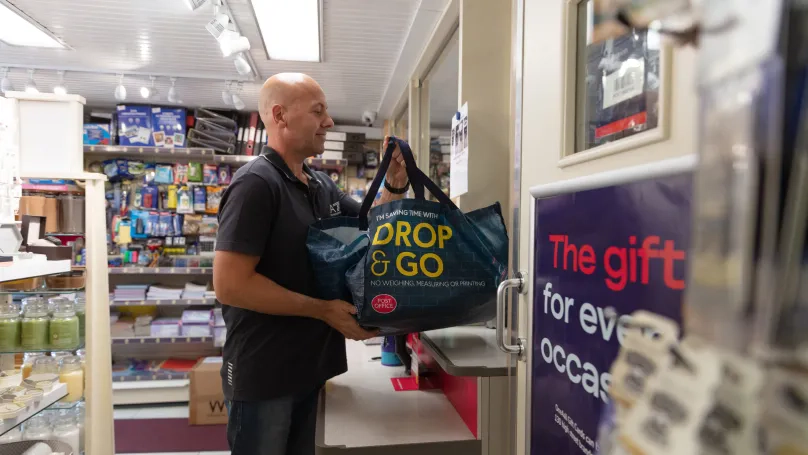 a customer handing a drop an go bag over a counter